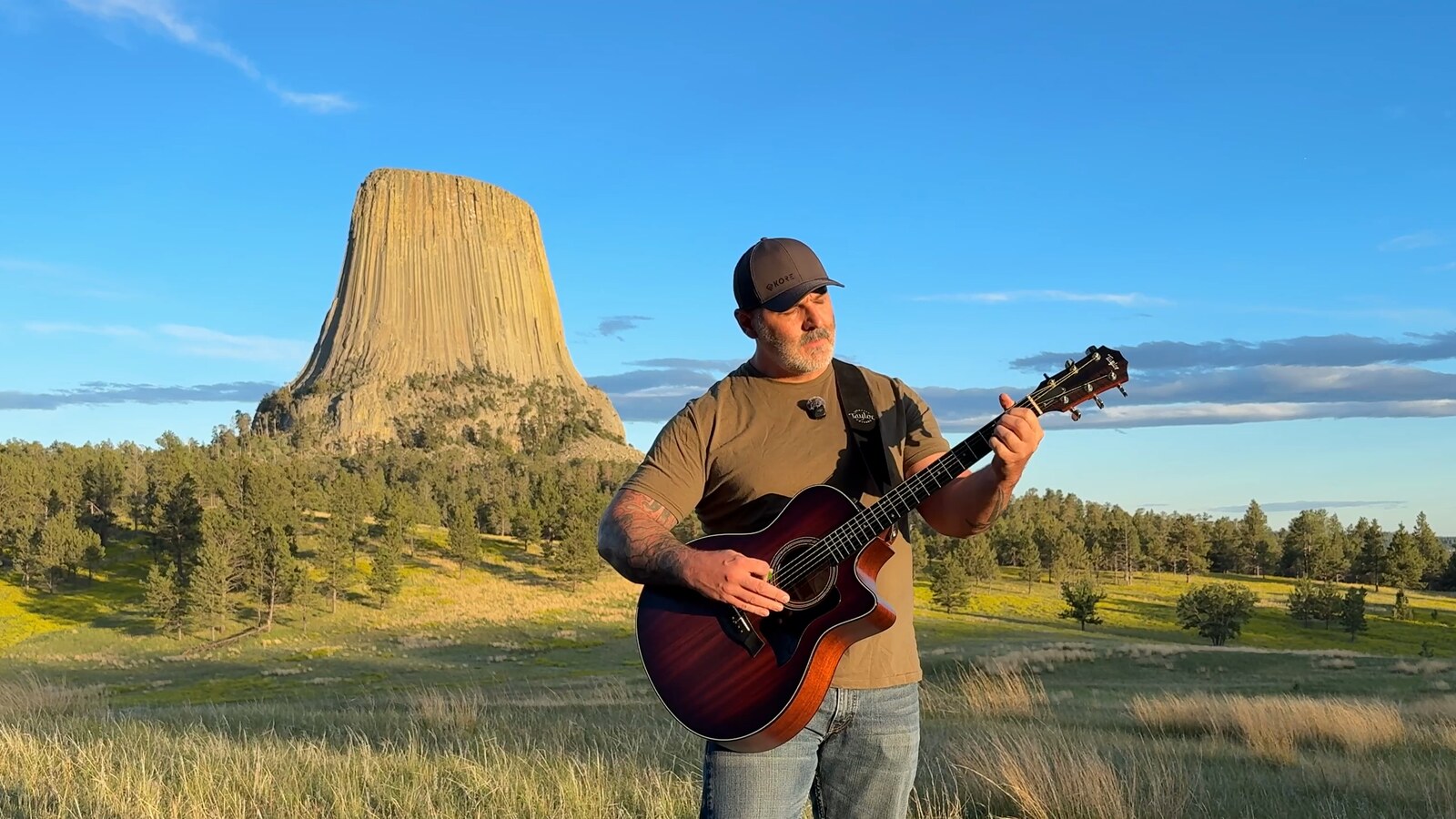 Michael Siebels playing guitar at the base of Devils Tower